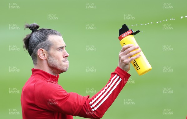 310821 - Wales Football Training - Gareth Bale sprays his team mates with water during a Wales training session ahead of their friendly against Finland and World Cup qualifying matches against Belarus and Estonia