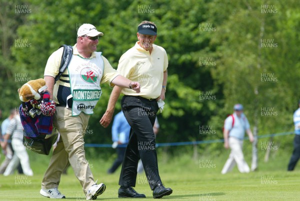 290503 - Wales Open Golf - Colin Montgomerie shares a joke with his caddie as he makes his way down the first fairway