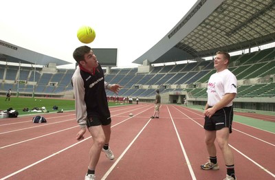 050601 - Wales Rugby Training - Michael Owen attempts the skills of his namesake while Phil Booth watches in awe at the impressive Nagai Stadium in Osaka
