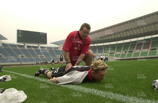 050601 - Wales Rugby Training - Alix Popham receives some treatment from team masseur Mike Wadsworth at the impressive Nagai Stadium, the venue for the game on Wednesday
