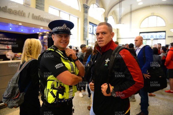 100815 - Wales Rugby Squad Travel to Colwyn Bay -Paul James meets a police officer as he arrive at Cardiff Central Station for the squads train to Colwyn Bay