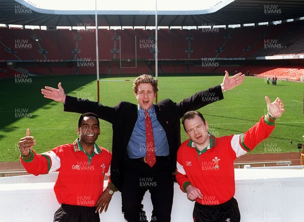 130395 - Wales Rugby Media Interviews - Singer Michael Ball, who will lead the Welsh players in their World Cup theme 'Bread of Heaven', pictured with players Nigel Walker (left) and Ieuan Evans (right) at Cardiff Arms Park