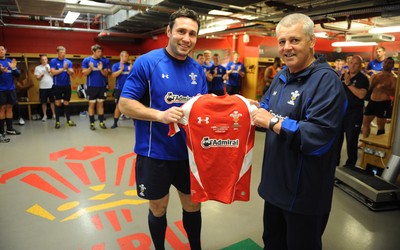 03.06.11 - WRU - Wales outside half Stephen Jones who will win his 100th Wales cap tomorrow against the Barbarians receives a shirt from head coach Warren Gatland in the changing rooms before the Wales captains run. 