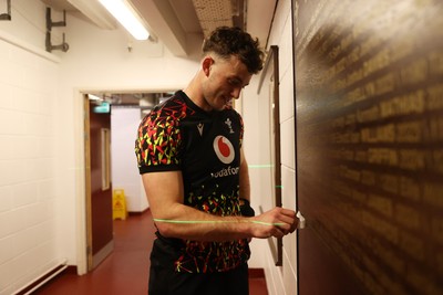 130326 - Wales Rugby Captains Run ahead of their last Six Nations game against Italy - Louie Hennessey puts his own name on the honours board in the stadium