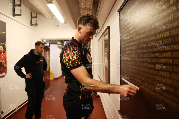 130326 - Wales Rugby Captains Run ahead of their last Six Nations game against Italy - Louie Hennessey puts his own name on the honours board in the stadium