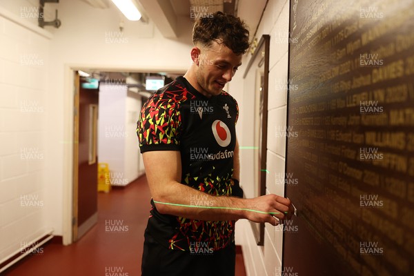 130326 - Wales Rugby Captains Run ahead of their last Six Nations game against Italy - Louie Hennessey puts his own name on the honours board in the stadium