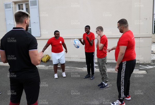 041023 - Picture shows the Wales Rugby Team visiting IME Le Rondo Croix Rouge in Versailles, a school for children with disabilities - Johnny Williams with the pupils playing catch