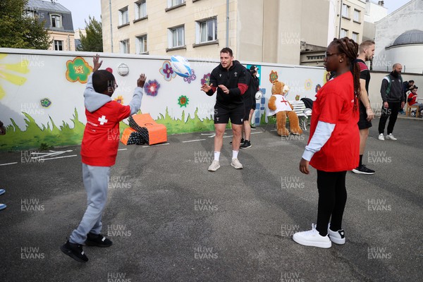 041023 - Picture shows the Wales Rugby Team visiting IME Le Rondo Croix Rouge in Versailles, a school for children with disabilities - Ryan Elias with the pupils playing catch