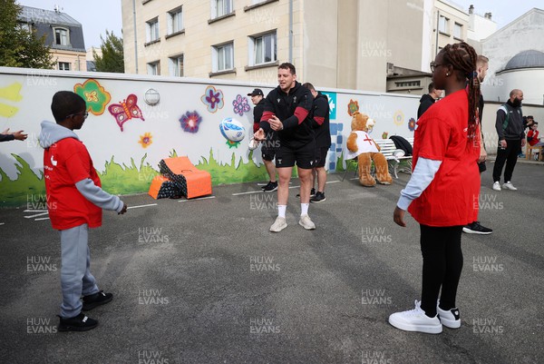 041023 - Picture shows the Wales Rugby Team visiting IME Le Rondo Croix Rouge in Versailles, a school for children with disabilities - Ryan Elias with the pupils playing catch