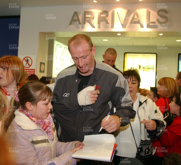 270205 - Gareth Thomas signs autographs with his left hand as the team arrive back in Cardiff after their victory in Paris