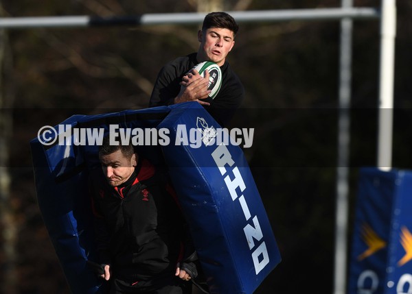 040222 - Wales Rugby Training - Louis Rees-Zammit jumps as Huw Bennett holds the pad during training