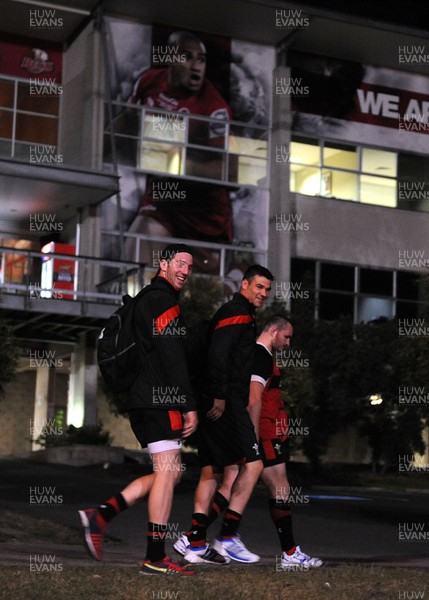 070612 - Wales Rugby Training -Alex Cuthbert, Mike Phillips and Ken Owens walk past a poster of Will Genia during training