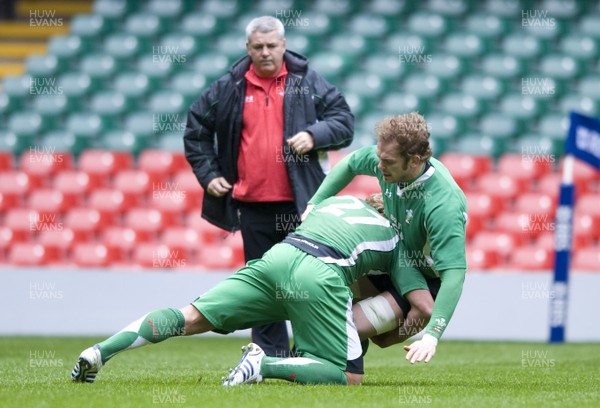 10.03.09 - Wales Rugby Training - Alun Wyn Jones is tackled by Andy Powell as head coach, Warren Gatland looks on during training. 