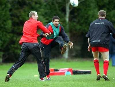 110203 - Wales Rugby Training - Wales Captain Colin Charvis chips ahead as he is tackled by Gareth Thomas