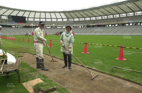 120601 - Wales Rugby Training - A female worker lays turf at the Tokyo Stadium while the team trains in readiness for the game against the Pacific Barbarians on Wednesday