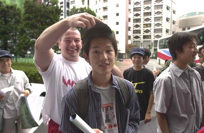 160601 - Wales Rugby Training - Andrew Lewis tries a baseball cap on a local before their training session in Tokyo