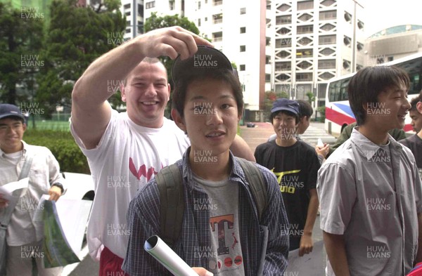 160601 - Wales Rugby Training - Andrew Lewis tries a baseball cap on a local before their training session in Tokyo