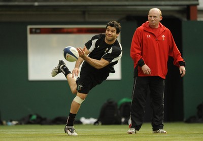 23.02.09 - Wales Rugby Training - Mike Phillips makes a pass as kicking coach, Neil Jenkins looks on during training. 