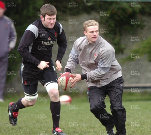 250206  Wales rugby training, Wanderers ground, Dublin Dwayne Peel passes watched by captain Michael Owen     