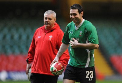 27.11.09 - Wales Rugby Training - Stephen Jones during training as head coach Warren Gatland looks on. 
