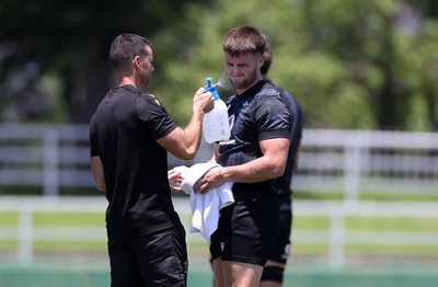 280625 - Wales Rugby Training Session in Kitakyushu - Joe Roberts is sprayed with water by Chris Edwards, Nutritionist during training