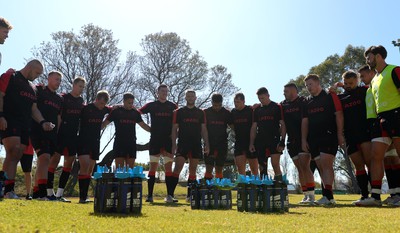 300622 - Wales Rugby Training - Dillon Lewis, Tommy Reffell, Liam Williams, Nick Tompkins, Kieran Hardy, Adam Beard, Dan Biggar, Talupe Faletau, Ryan Elias, Josh Adams, Gareth Thomas, Rhys Carre, Tomas Francis, Taine Basham, Johnny Williams huddle during training