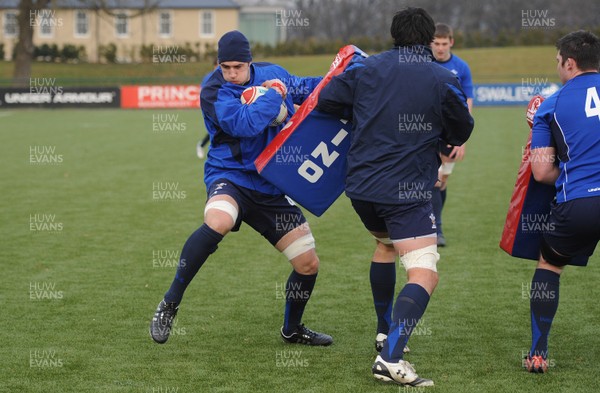 31.01.11 - Wales Rugby Training - Josh Turnbull hits the tackle bag of Jonathan Thomas during training. 