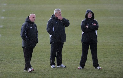 01.02.10 - Wales Rugby Training - Wales head coach Warren Gatland(c), defence coach Shaun Edwards(L) and backs coach Rob Howley(r) look on during training. 