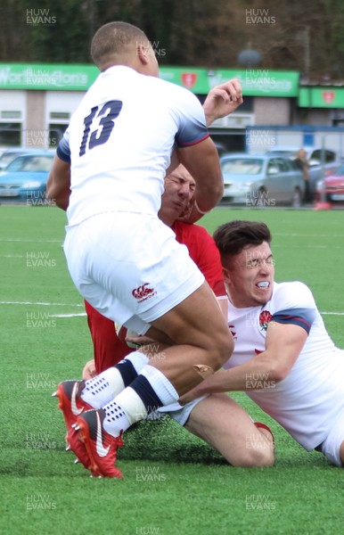 250318 - Wales U18 v England U18 - Deon Smith of Wales is tackled by Kieran Wilkinson of England and Ollie Lawrence of England