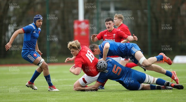 310318 - Wales U18 v France U18, U18s Six Nations Festival, Ystrad Mynach - Archie Griffin of Wales is tackled by Florent Vanverberghe of France