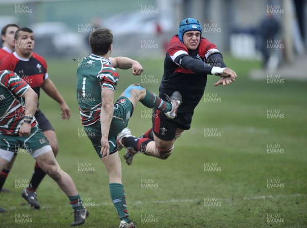 120213 - Wales U18 v Leicester Tigers Academy -   Ollie Hitchins of Wales attempts to block the kick by George Tresidder of Leicester Academy