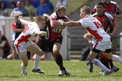 13.06.09 Wales U18's v England Lionhearts U18's The Old Parish, Maesteg -  Dafydd Carter hands off Ben Mullen(16) as he leaves Jake Cotterell(L) grasping at thin air. 