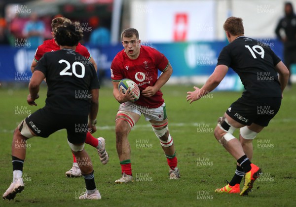 240623 - Wales v New Zealand - World Rugby U20 Championship - Morgan Morse of Wales looks for the gap between Malachi Wrampling-Alec of New Zealand and Tom Allen of New Zealand
