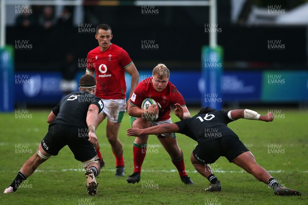 240623 - Wales v New Zealand - World Rugby U20 Championship - Louis Fletcher of Wales attempts to get past Raymond Tuputupu of New Zealand attempted tackle
