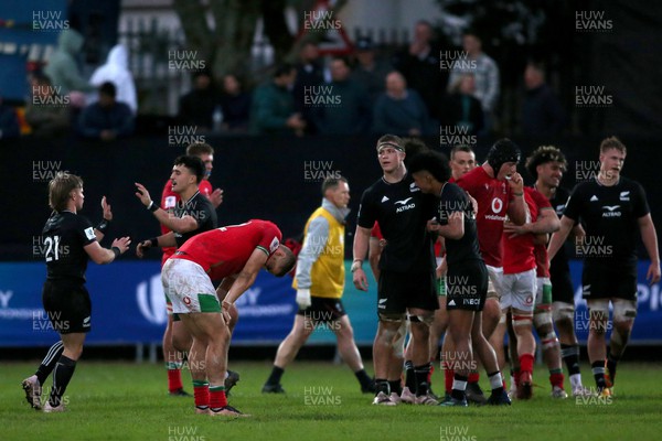 240623 - Wales v New Zealand - World Rugby U20 Championship - Dejected Bryn Bradley of Wales reacts as New Zealand players celebrate winning 27-26