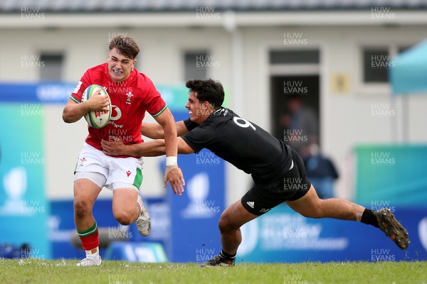 240623 - Wales v New Zealand - World Rugby U20 Championship - Llien Morgan of Wales attempts to slip New Zealand captain Noah Hotham tackle 