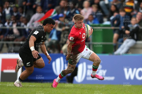 240623 - Wales v New Zealand - World Rugby U20 Championship - Archie Hughes of Wales attempts to get away from Ajay Faleafaga of New Zealand