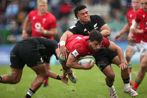 240623 - Wales v New Zealand - World Rugby U20 Championship - Lucas De La Rua of Wales is tackled off his feet by Ajay Faleafaga of New Zealand and Aki Tuivailala of New Zealand