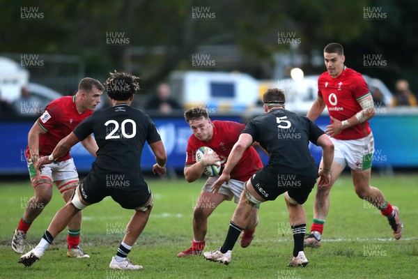 240623 - Wales v New Zealand - World Rugby U20 Championship - Dylan Kelleher-Griffiths of Wales attempts to get past Malachi Wrampling-Alec of New Zealand and Will Stodart of New Zealand