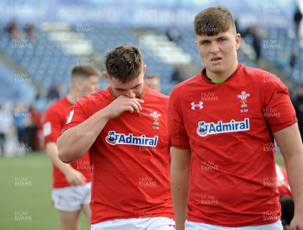 220619 - Wales U20 v England U20 - World Rugby Under 20 Championship - 5th Place Final -  Wales players Ed Scragg (front) and Kemsley Mathias of Wales leave the field dejected at full time