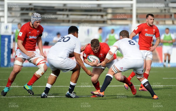 220619 - Wales U20 v England U20 - World Rugby Under 20 Championship - 5th Place Final -  Rhys Davies of Wales is tackled by Rusiate Tuima (20) and number 8 Tom Willis