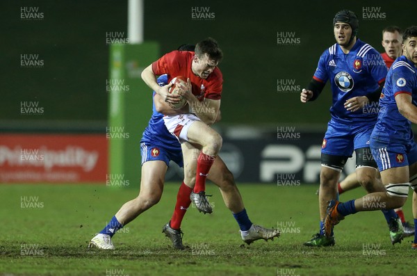 160318 - Wales U20s v France U20s - Natwest 6 Nations Championship - Cai Evans of Wales is tackled by Jean Gros of France