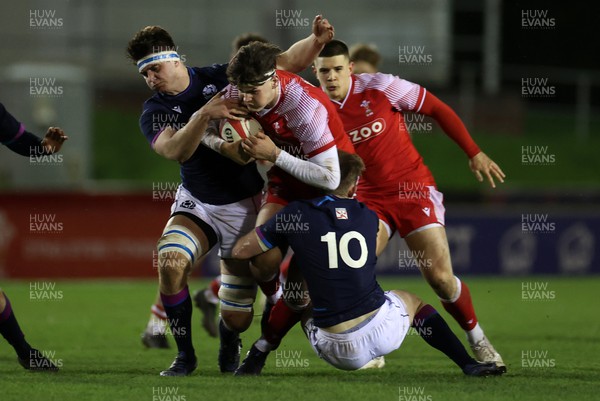 110222 - Wales U20s v Scotland U20s - U20s Six Nations Championship - Eddie James of Wales is tackled by Josh Taylor and Christian Townsend of Scotland