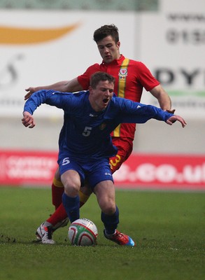 220313 - Wales U21 v Moldova U21 UEFA Championship Qualifying match, Llanelli - Moldova's Vasile Jardan is brought down by Wales' Jonathan Meades