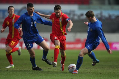 220313 - Wales U21 v Moldova U21 UEFA Championship Qualifying match, Llanelli - Wales' Lee Lucas takes on Moldova's Ivan Prodan and Moldova's Vasile Jardan