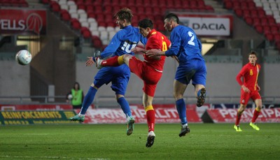 220313 - Wales U21 v Moldova U21 UEFA Championship Qualifying match, Llanelli - Wales' Joe Walsh gets a shot at goal as he gets between Moldova's Catalin Carp and Moldova's Ivan Prodan