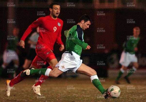 280206 - Wales U21 v Northern Ireland U21 - International Under 21 Challenge Match - Stebonheath Park, Llanelli - Northern Ireland's Jim Ervin takes the ball forwards as Craig Davies closes in 