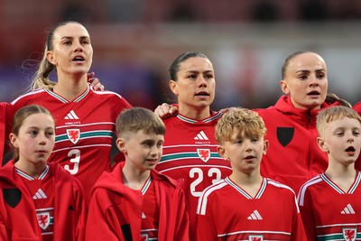 140426 - Wales v Albania - 2027 FIFA Women's World Cup Qualifying - Gemma Evans, Ffion Morgan and Lily Woodham of Wales sing the national anthem