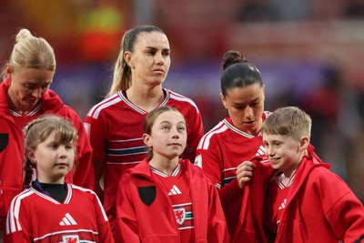 140426 - Wales v Albania - 2027 FIFA Women's World Cup Qualifying - Ffion Morgan of Wales gives her jacket to a mascot during the anthems