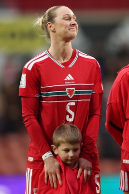 140426 - Wales v Albania - 2027 FIFA Women's World Cup Qualifying - Rhiannon Roberts of Wales reacts after giving a mascot her jacket